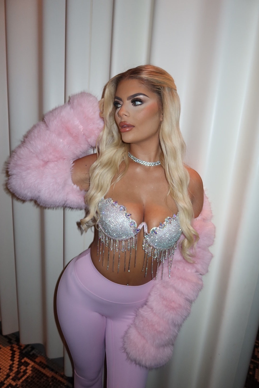 GLAMORZ baby pink diamante bra top with crystal fringe detail worn by a blonde model with a pink faux fur shrug.