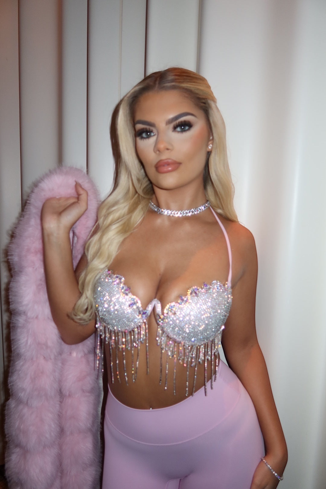 GLAMORZ baby pink diamante bra top with crystal fringe detail worn by a blonde model with a matching faux fur stole