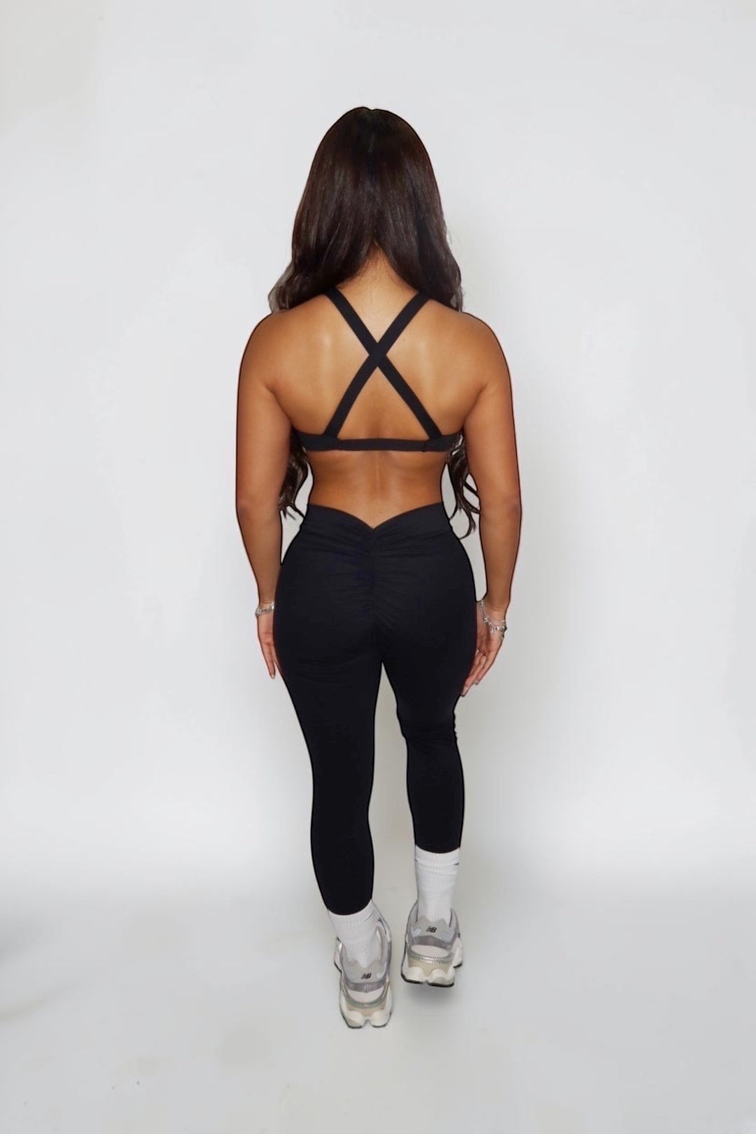 GLAMORZ black BBL bra and matching leggings with a ruched back detail worn by a woman from the back view