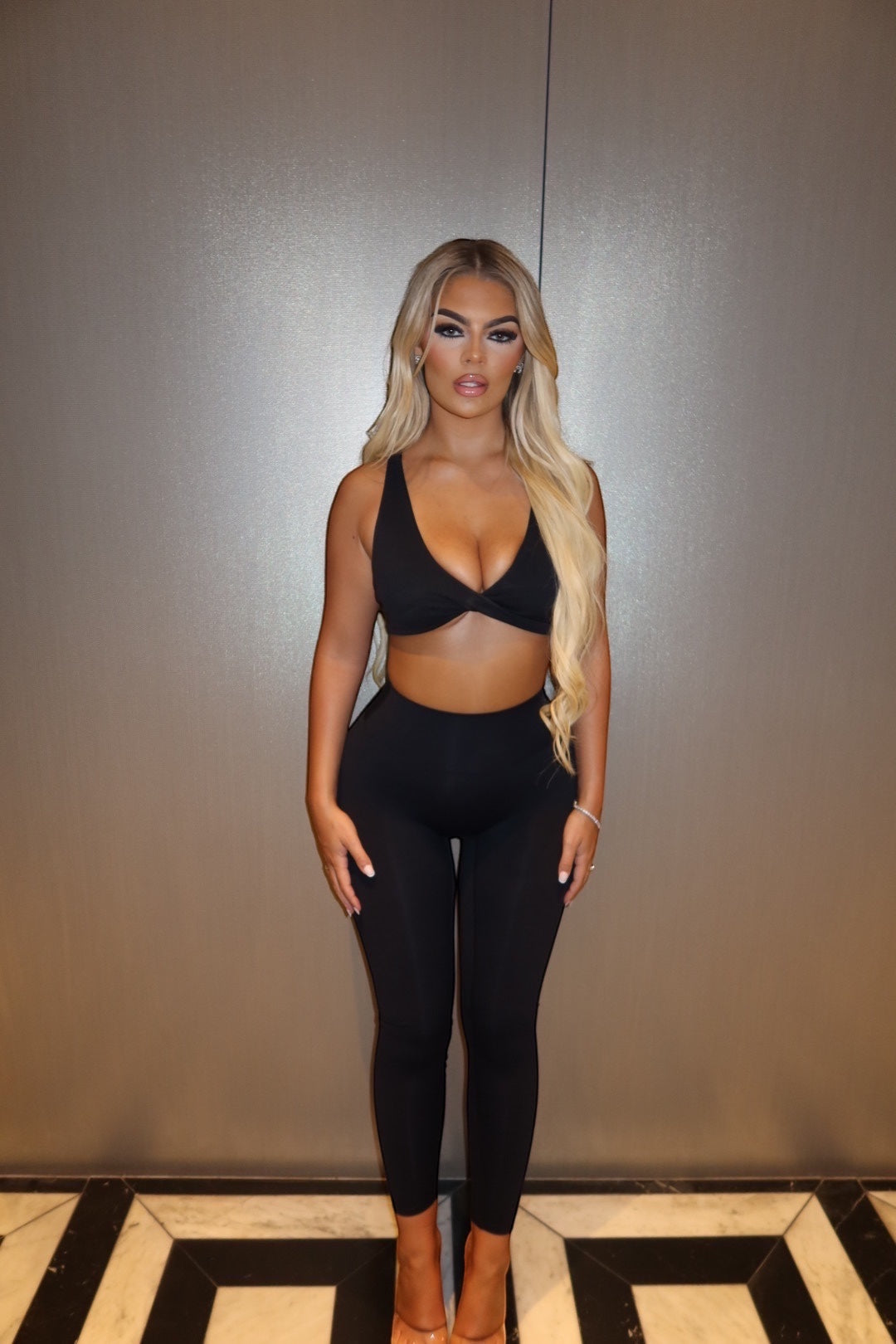 GLAMORZ black velour BBL bra worn by a blonde model with matching high-waisted leggings against a neutral wall.