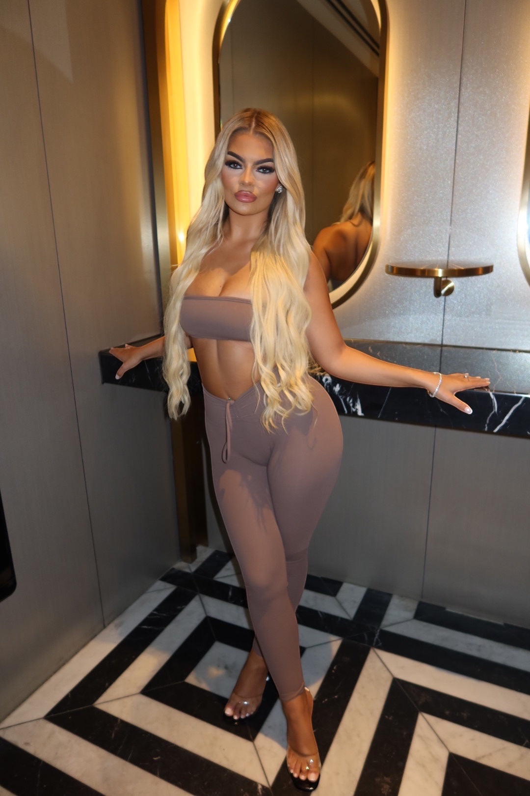 GLAMORZ KHY brown scrunch leggings and matching bandeau top worn by a blonde model in a modern interior