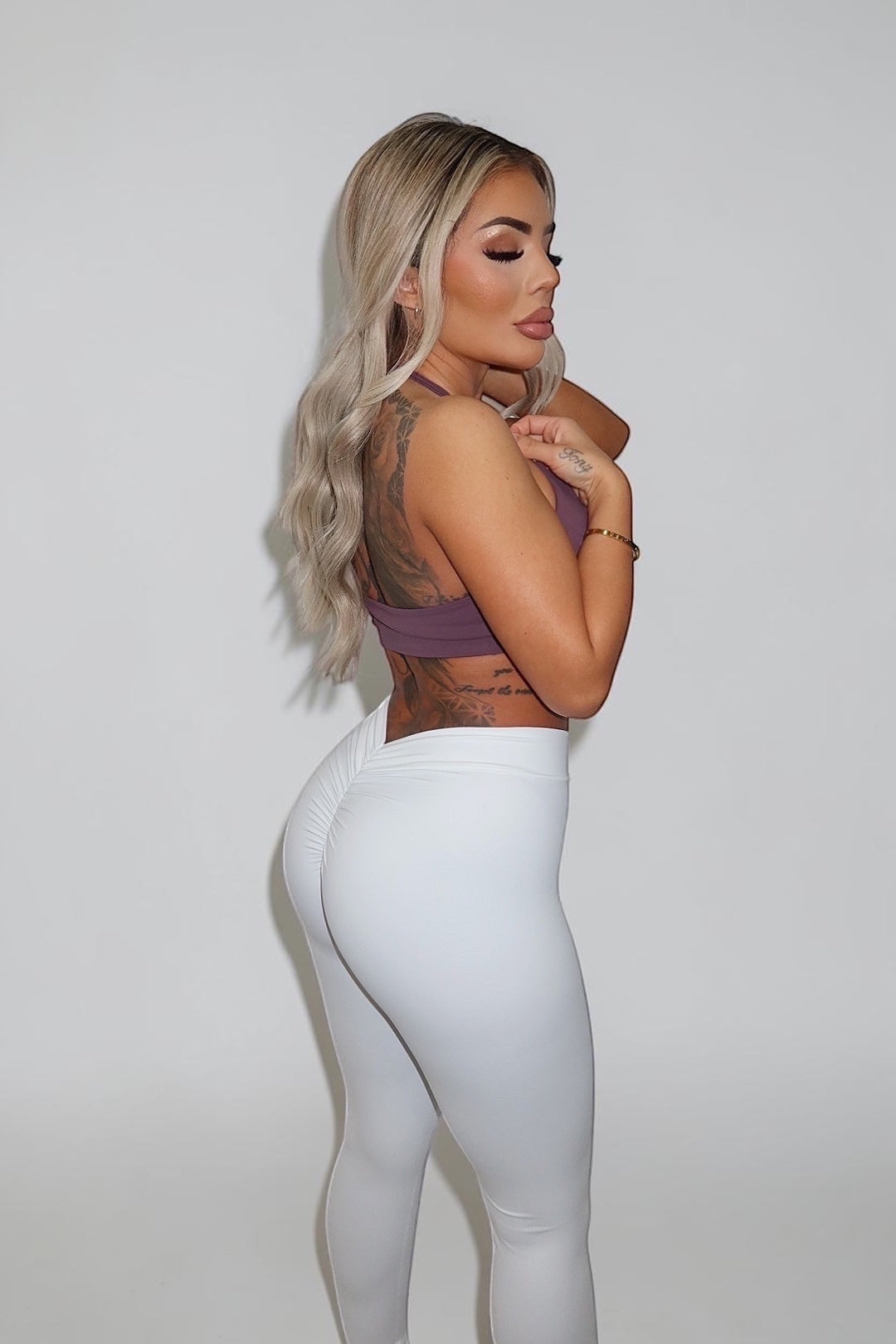 GLAMORZ mauve Sculptra halter bra paired with white high-waisted ruched leggings on a blonde model