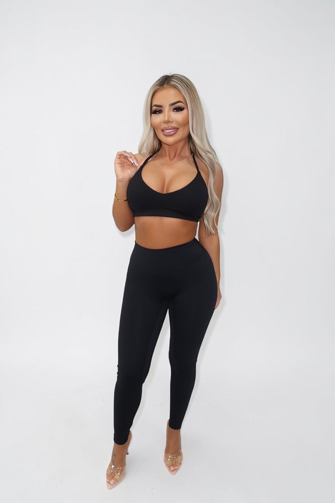 GLAMORZ Sculptra halter bra in black worn by a blonde model with matching black leggings against a white background.