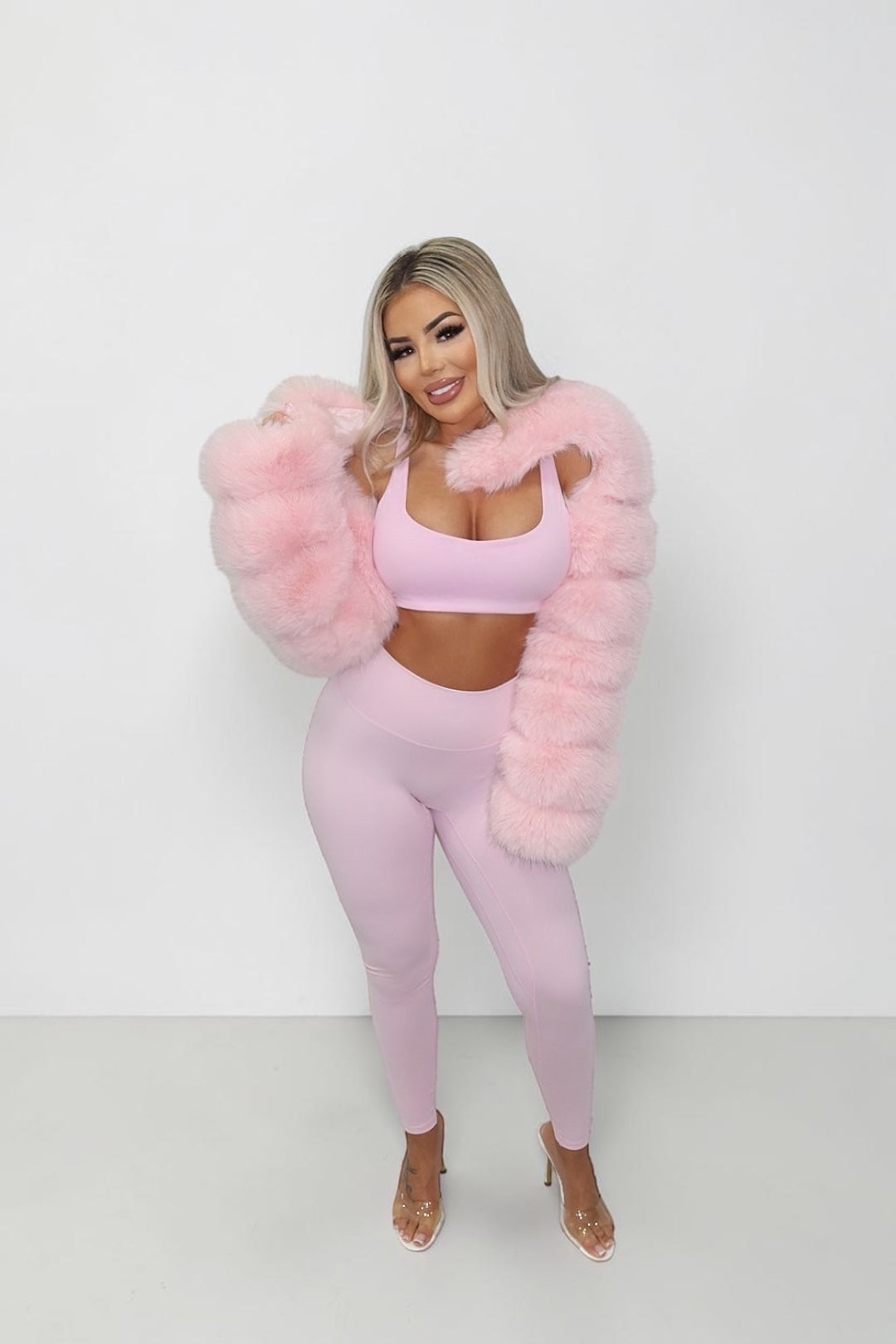 GLAMORZ Simplicity bra in baby pink worn by a blonde model with a matching pink faux fur jacket and leggings