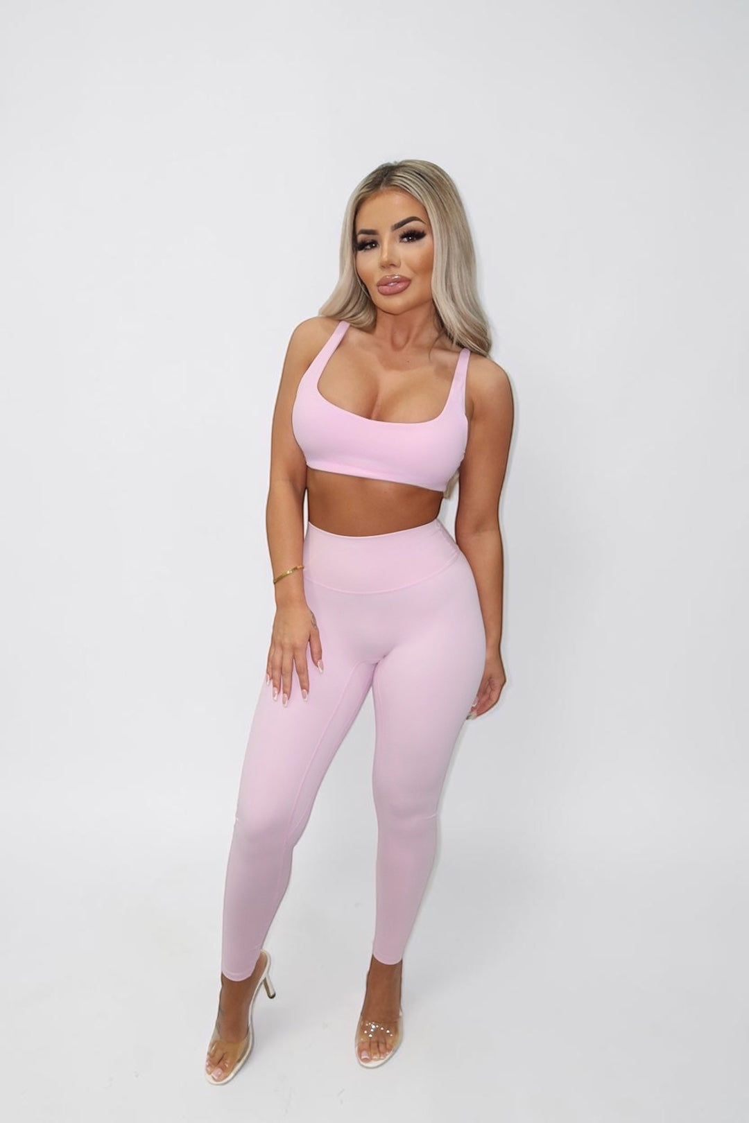 GLAMORZ Simplicity bra in baby pink worn by a blonde model with matching high-waisted leggings and clear heels.