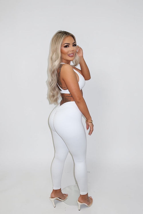 GLAMORZ white BBL scrunch leggings worn by a blonde woman with a matching sports bra against a white background