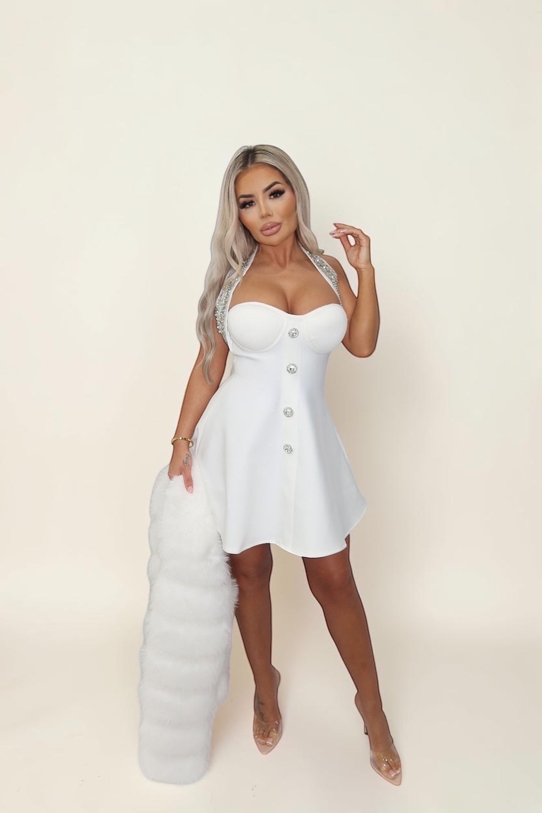 GLAMORZ white mini dress with rhinestone straps and buttons, paired with a matching white faux fur sleeve accessory.